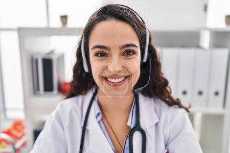 Photo for Young doctor woman working on online appointment looking positive and happy standing and smiling with a confident smile showing teeth - Royalty Free Image