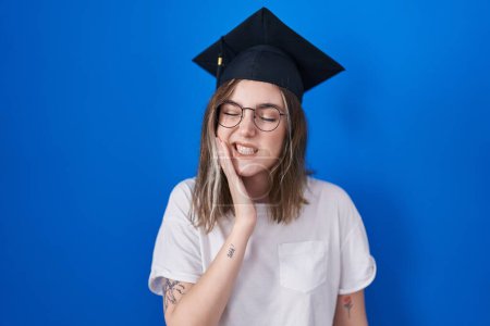 Photo for Blonde caucasian woman wearing graduation cap touching mouth with hand with painful expression because of toothache or dental illness on teeth. dentist - Royalty Free Image