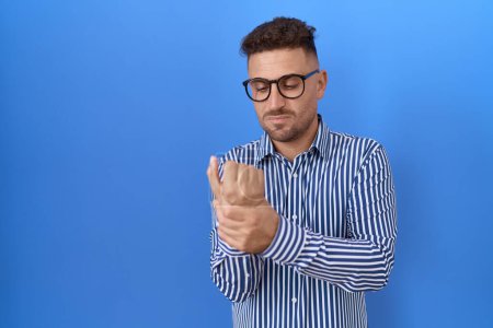 Photo for Hispanic man with beard wearing glasses suffering pain on hands and fingers, arthritis inflammation - Royalty Free Image