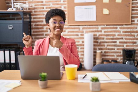 Téléchargez les photos : Jeune femme afro-américaine travaillant au bureau portant des lunettes souriant et regardant la caméra pointant avec deux mains et doigts sur le côté. - en image libre de droit