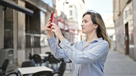 Photo for Young blonde woman making selfie by the smartphone at coffee shop terrace - Royalty Free Image