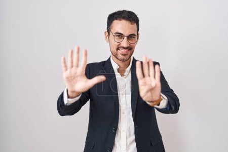 Photo for Handsome business hispanic man standing over white background showing and pointing up with fingers number nine while smiling confident and happy. - Royalty Free Image