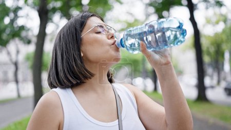 Photo for Young beautiful hispanic woman standing drinking water at the park in Vienna - Royalty Free Image