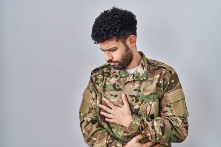 Foto de Hombre árabe vistiendo uniforme camuflaje del ejército con la mano en el estómago porque la indigestión, la enfermedad dolorosa sensación de malestar. concepto ache. - Imagen libre de derechos