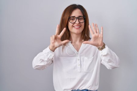 Photo for Brunette woman standing over white isolated background showing and pointing up with fingers number eight while smiling confident and happy. - Royalty Free Image