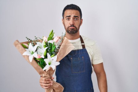 Photo for Hispanic man with beard working as florist depressed and worry for distress, crying angry and afraid. sad expression. - Royalty Free Image