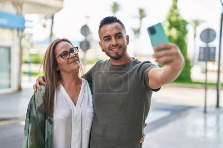 Photo for Man and woman mother and daugther make selfie by smartphone at street - Royalty Free Image