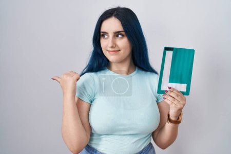 Photo for Young modern girl with blue hair holding l sign for new driver pointing thumb up to the side smiling happy with open mouth - Royalty Free Image