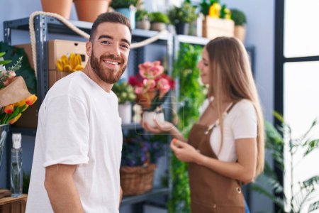Téléchargez les photos : Homme et femme client demandant à fleuriste pour pot de plante à la boutique de fleurs - en image libre de droit