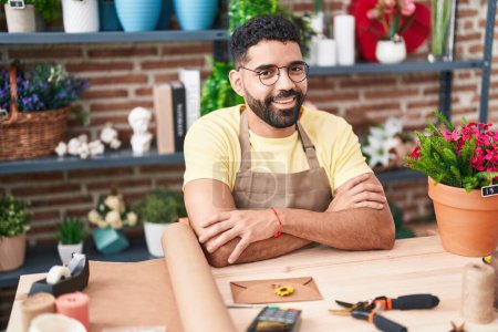 Photo for Young arab man florist smiling confident sitting with arms crossed gesture at florist - Royalty Free Image
