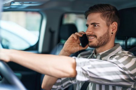 Téléchargez les photos : Jeune homme caucasien parlant sur smartphone assis sur la voiture à la rue - en image libre de droit