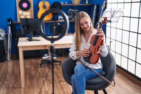 Téléchargez les photos : Young caucasian woman musician having online violin lesson at music studio - en image libre de droit