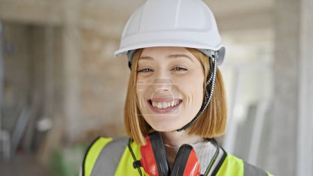 Téléchargez les photos : Jeune femme blonde architecte souriant confiant debout sur le chantier de construction - en image libre de droit