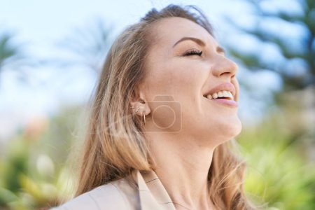 Téléchargez les photos : Young blonde woman smiling confident breathing at park - en image libre de droit
