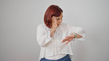 Foto de Mujer de mediana edad mirando reloj sorprendido sobre fondo blanco aislado - Imagen libre de derechos