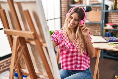 Photo for Young woman artist listening to music drawing at art studio - Royalty Free Image