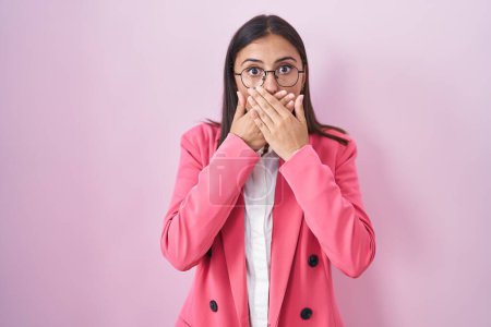 Photo for Young hispanic woman wearing business clothes and glasses shocked covering mouth with hands for mistake. secret concept. - Royalty Free Image
