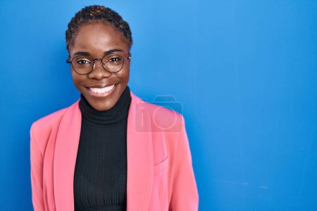 Photo for Beautiful black woman standing over blue background with a happy and cool smile on face. lucky person. - Royalty Free Image