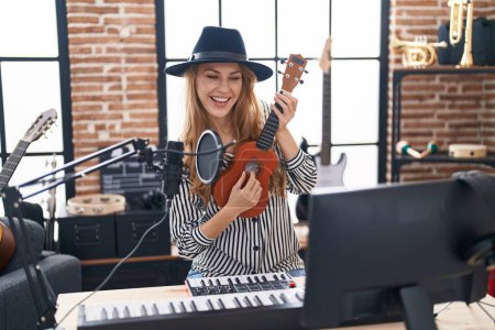 Téléchargez les photos : Jeune femme blonde musicienne chantant chanson jouant ukelele au studio de musique - en image libre de droit