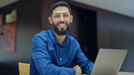 Téléchargez les photos : Jeune homme hispanique travailleur d'affaires en utilisant un ordinateur portable travaillant au bureau - en image libre de droit