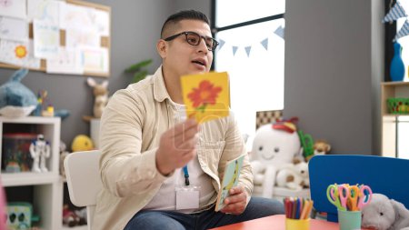 Foto de Joven hispano maestro de preescolar enseñando lección de vocabulario en el jardín de infantes - Imagen libre de derechos