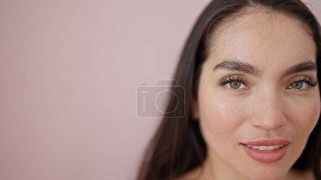 Foto de Joven hermosa mujer hispana sonriendo confiada sobre fondo rosa aislado - Imagen libre de derechos