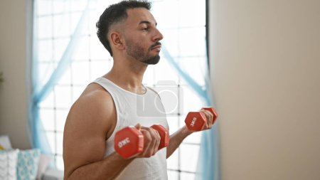 Photo for Young arab man using dumbbells training at home - Royalty Free Image