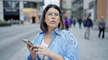 Foto de Joven mujer hispana hermosa usando smartphone esperando un taxi en las calles de Viena - Imagen libre de derechos