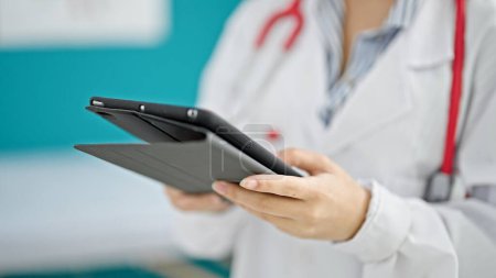 Foto de Mujer pelirroja joven médico usando touchpad en la clínica - Imagen libre de derechos