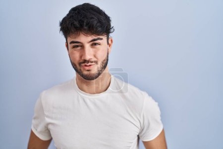 Photo for Hispanic man with beard standing over white background looking at the camera blowing a kiss on air being lovely and sexy. love expression. - Royalty Free Image