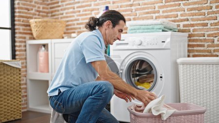 Photo for Middle age man washing clothes at laundry room - Royalty Free Image