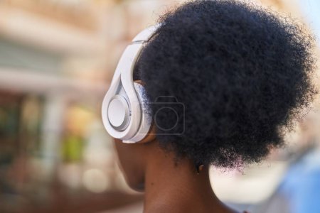 Téléchargez les photos : Femme afro-américaine écoutant de la musique dans la rue - en image libre de droit