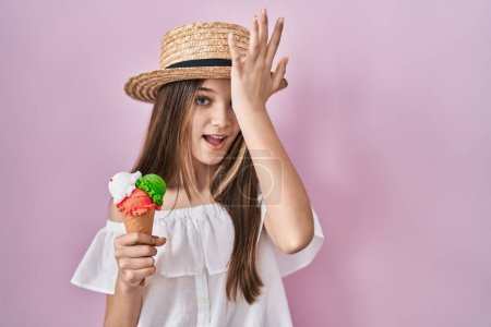 Téléchargez les photos : Adolescente tenant de la crème glacée surpris avec la main sur la tête pour erreur, rappelez-vous erreur. oublié, mauvais concept de mémoire. - en image libre de droit