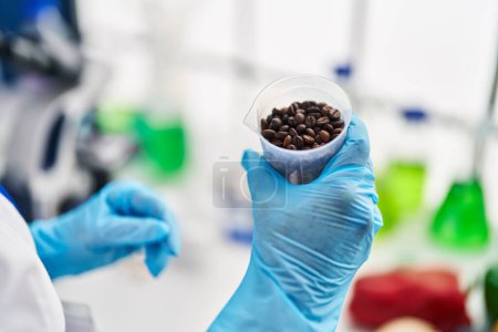 Téléchargez les photos : Femme scientifique d'âge moyen tenant des grains de café au laboratoire - en image libre de droit