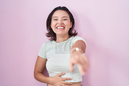 Téléchargez les photos : Jeune femme hispanique debout sur fond rose se moquant de vous, pointant du doigt la caméra avec la main sur le corps, expression de honte - en image libre de droit
