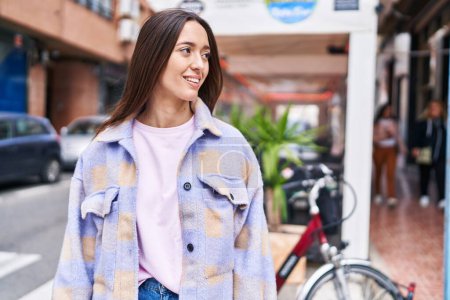 Téléchargez les photos : Jeune belle femme hispanique souriant confiant regardant vers le côté à la terrasse du café - en image libre de droit