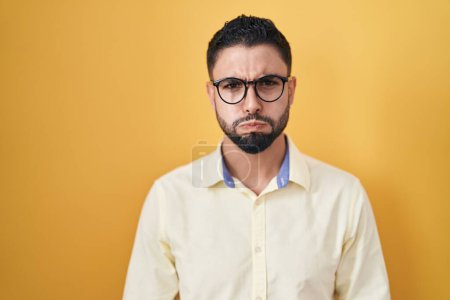 Photo for Hispanic young man wearing business clothes and glasses puffing cheeks with funny face. mouth inflated with air, crazy expression. - Royalty Free Image
