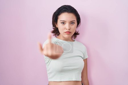 Téléchargez les photos : Hispanic young woman standing over pink background showing middle finger, impolite and rude fuck off expression - en image libre de droit