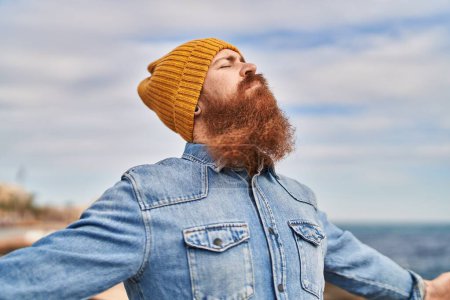 Photo for Young redhead man breathing at seaside - Royalty Free Image