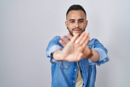 Téléchargez les photos : Jeune homme hispanique debout sur fond isolé expression de rejet traversant les bras et les paumes faisant signe négatif, visage en colère - en image libre de droit