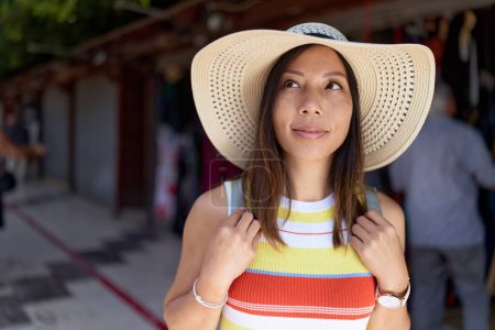 Foto de Joven asiático mujer turista sonriendo confiado de pie en la calle mercado - Imagen libre de derechos