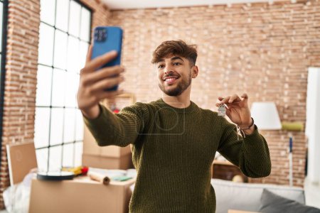 Photo for Young arab man make selfie by smartphone holding key at new home - Royalty Free Image