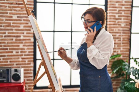 Téléchargez les photos : Femme artiste du Moyen Âge parlant sur smartphone dessin au studio d'art - en image libre de droit