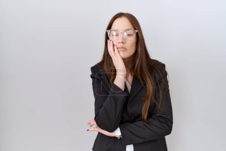 Photo for Beautiful brunette woman wearing business jacket and glasses thinking looking tired and bored with depression problems with crossed arms. - Royalty Free Image
