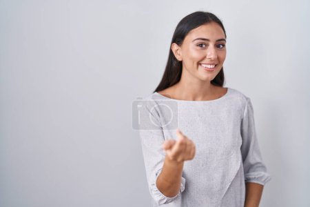 Téléchargez les photos : Young hispanic woman standing over white background beckoning come here gesture with hand inviting welcoming happy and smiling - en image libre de droit