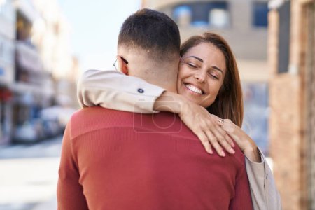Photo for Man and woman mother and son hugging each other at street - Royalty Free Image
