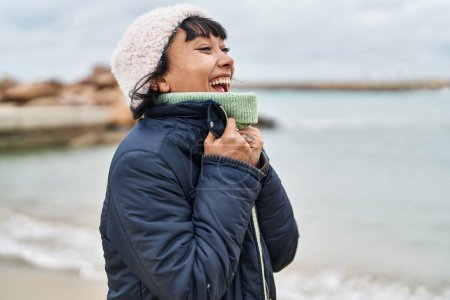 Téléchargez les photos : Jeune belle femme hispanique souriant confiance debout au bord de la mer - en image libre de droit