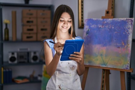 Téléchargez les photos : Adorable girl artist using touchpad drawing at art studio - en image libre de droit