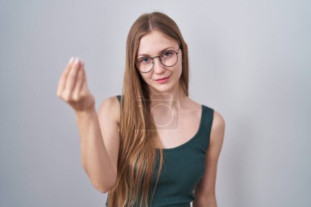 Foto de Joven mujer caucásica de pie sobre fondo blanco haciendo gesto italiano con la mano y los dedos expresión confiada - Imagen libre de derechos