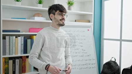 Photo for Young hispanic man teacher teaching maths lesson at university classroom - Royalty Free Image